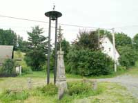 litinov kek s kamennm podstavcem v Podol, v pozad zvonika