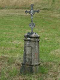 litinový křížek s kamenným podstavcem v Podolí při silnici na Běšiny