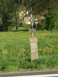 litinový křížek s kamenným podstavcem na rozcestí při výjezdu ze Smrčí na hlavní silnici