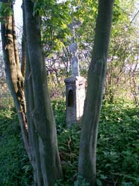 litinový křížek s kamenným podstavcem u návesního rybníka ve Vlčkovicích